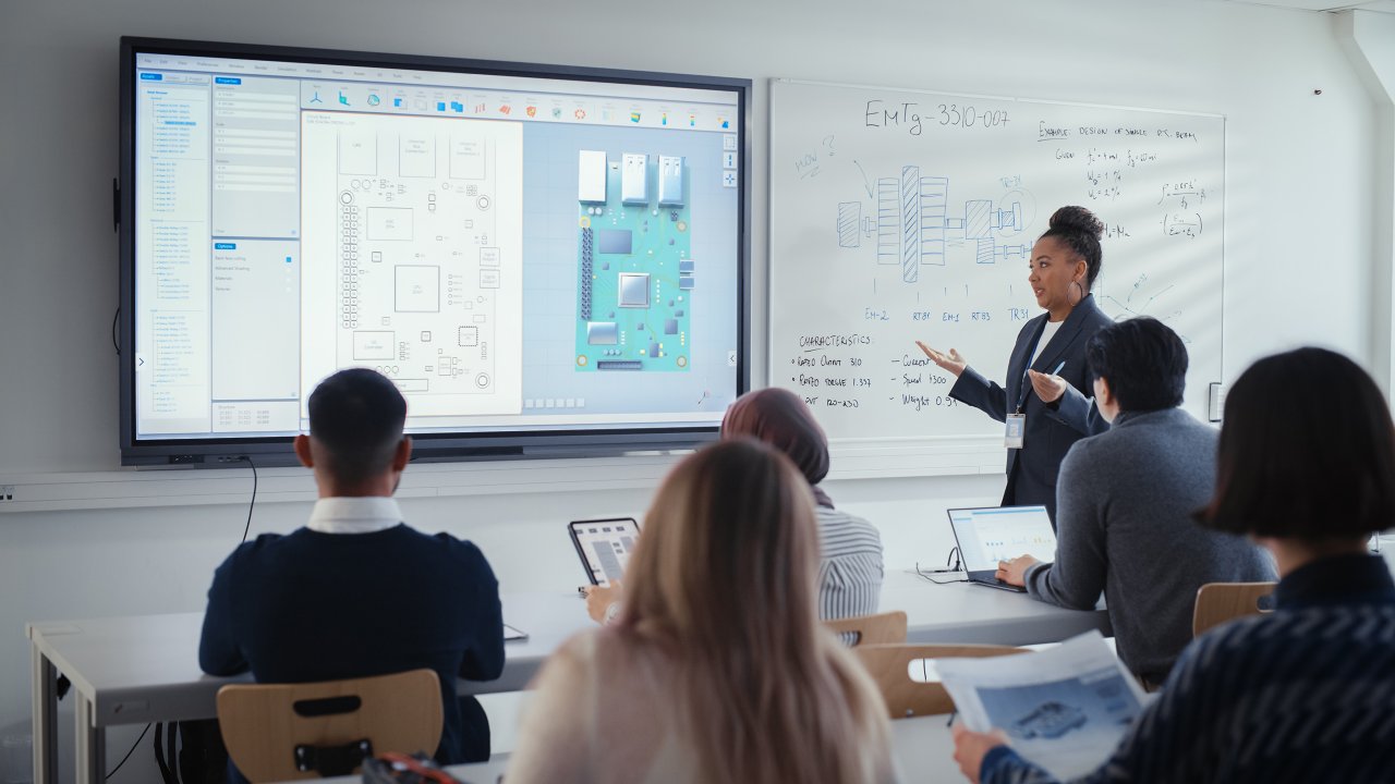 Black Female Teacher Using Digital Interactive Screen, Talks to Group of Diverse Students and Shows 3D Circuit Board Components. Education